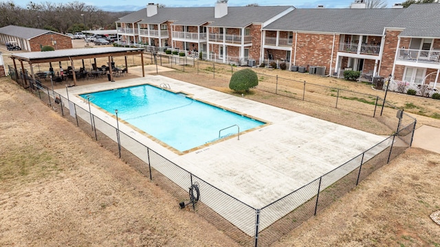 view of swimming pool featuring a yard, central AC unit, and a patio area