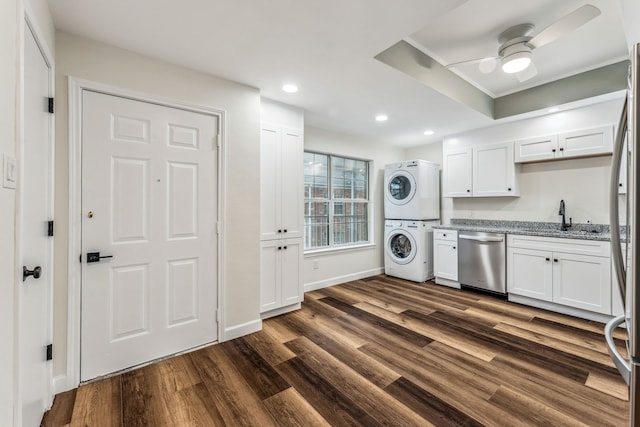 washroom with sink, dark hardwood / wood-style floors, stacked washer and clothes dryer, and ceiling fan