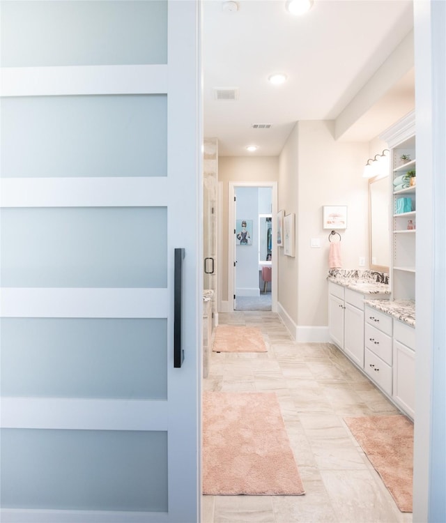 bathroom featuring vanity and a shower with shower door