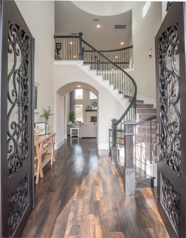 entrance foyer featuring a towering ceiling and dark hardwood / wood-style flooring