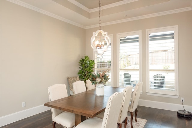 dining space featuring crown molding, a tray ceiling, dark hardwood / wood-style flooring, and an inviting chandelier