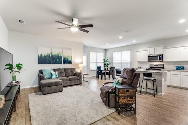living area featuring visible vents, recessed lighting, and a ceiling fan