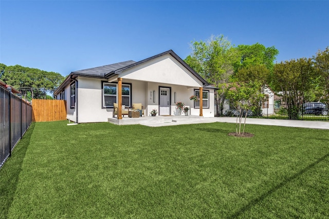 view of front of property featuring solar panels, a patio, and a front lawn