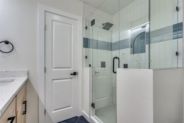 bathroom with a shower with door and vanity