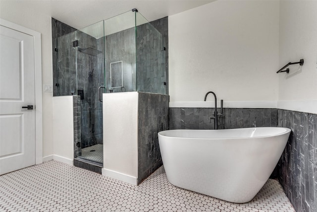 bathroom with tile walls and shower with separate bathtub