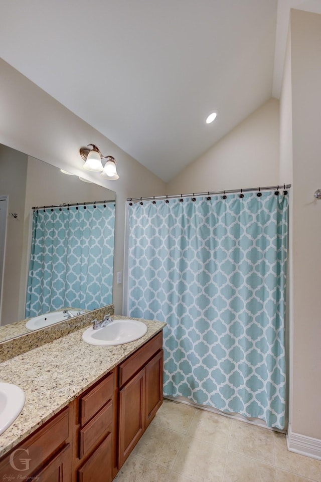 bathroom featuring vanity, tile patterned flooring, and vaulted ceiling