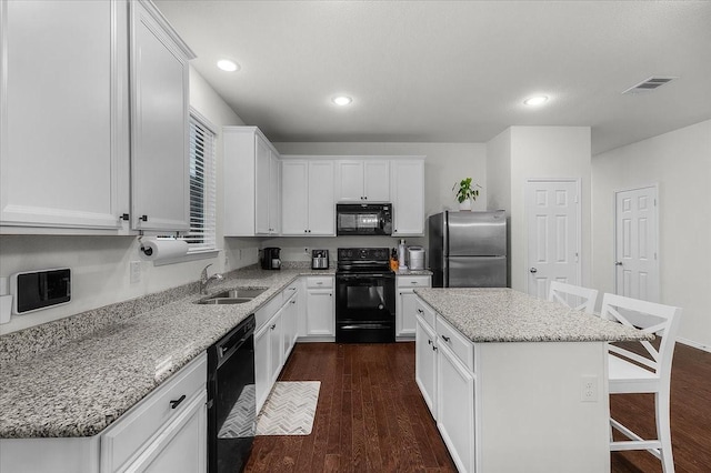 kitchen with sink, black appliances, white cabinets, and a kitchen island