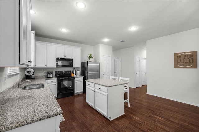 kitchen with white cabinetry, dark wood-type flooring, black appliances, and a kitchen island