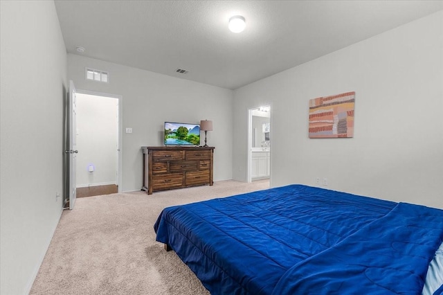 carpeted bedroom featuring ensuite bathroom