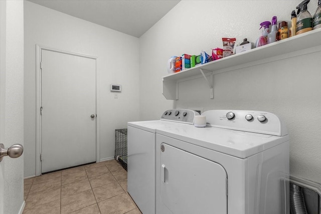 laundry room featuring separate washer and dryer and light tile patterned floors