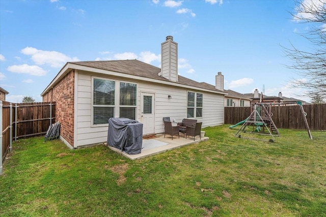 rear view of house featuring a playground, a patio, and a yard