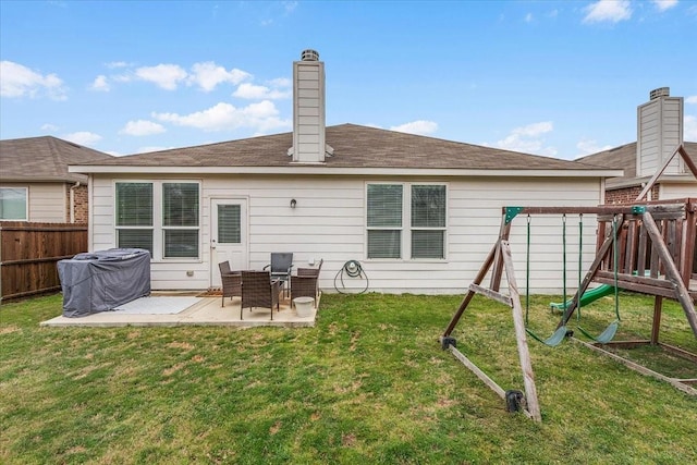 back of property with a playground, a patio, and a yard