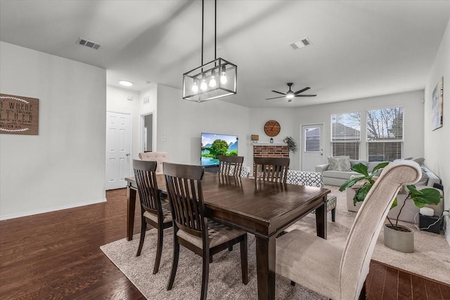 dining space with dark wood-type flooring and ceiling fan