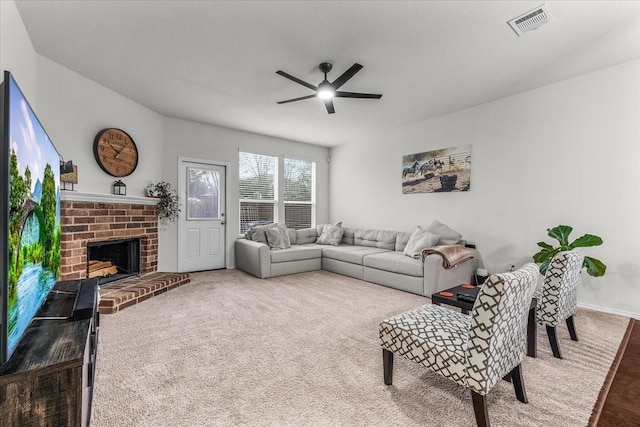 living room with ceiling fan, carpet floors, and a brick fireplace