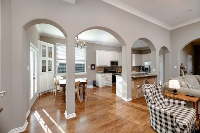 dining room with ornamental molding and light hardwood / wood-style floors