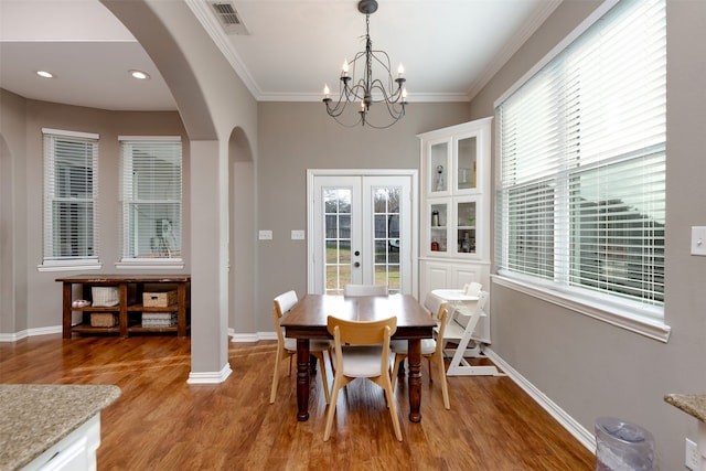 dining space with crown molding, hardwood / wood-style floors, and french doors