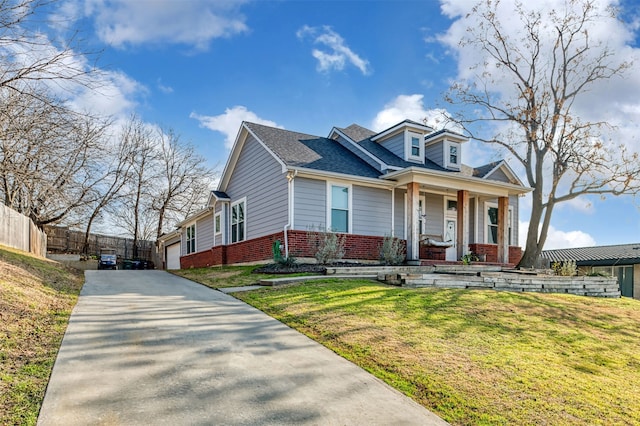 view of front of house featuring a porch, a garage, and a front lawn