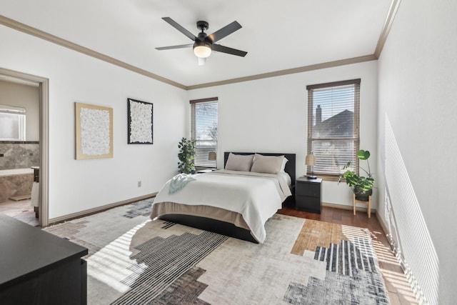 bedroom featuring a ceiling fan, wood finished floors, connected bathroom, crown molding, and baseboards