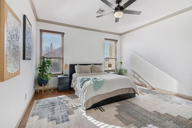 bedroom with crown molding, hardwood / wood-style floors, and ceiling fan