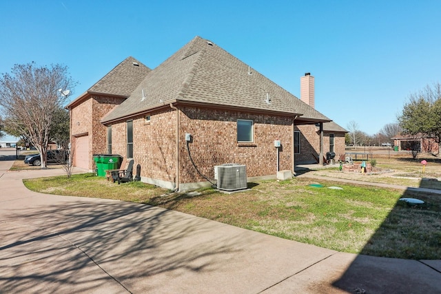 view of property exterior featuring central AC unit, driveway, roof with shingles, a chimney, and brick siding