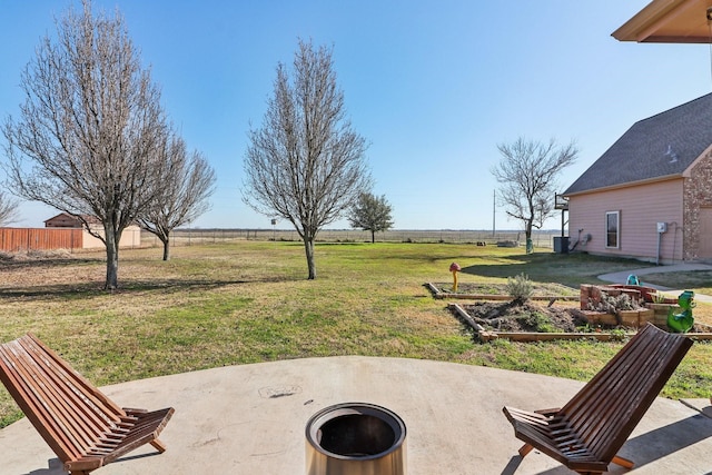 view of yard with a rural view, a fire pit, and a patio area