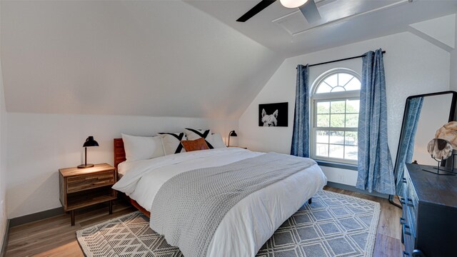 bedroom featuring ceiling fan, lofted ceiling, a textured ceiling, and light wood-type flooring