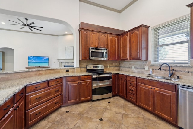 kitchen with sink, light stone counters, crown molding, appliances with stainless steel finishes, and backsplash