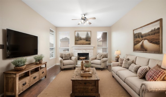 living room featuring ceiling fan, dark wood-type flooring, and a fireplace