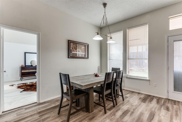 dining room with hardwood / wood-style floors and a textured ceiling