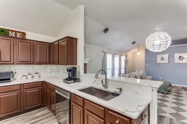 kitchen featuring vaulted ceiling, dishwasher, sink, backsplash, and kitchen peninsula