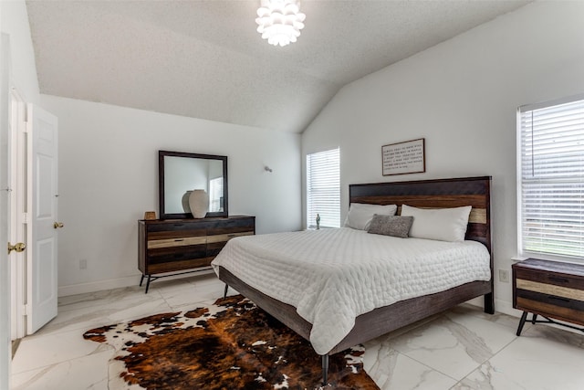 bedroom featuring multiple windows, lofted ceiling, a chandelier, and a textured ceiling