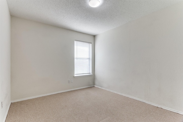 carpeted empty room featuring a textured ceiling