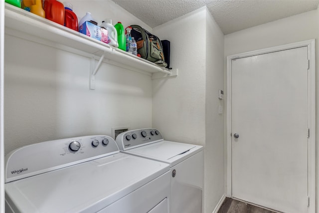 laundry area featuring dark hardwood / wood-style flooring, washer and clothes dryer, and a textured ceiling