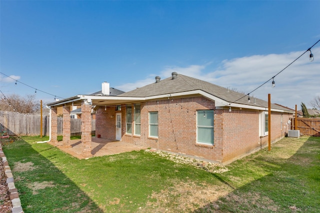 rear view of house featuring a lawn, a patio, and central air condition unit