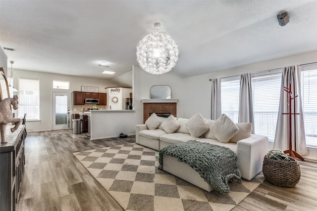 living room featuring plenty of natural light, a fireplace, and light hardwood / wood-style flooring