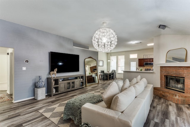 living room featuring a notable chandelier, wood-type flooring, and a fireplace