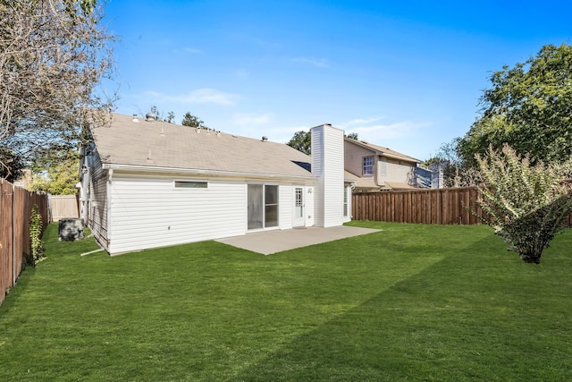 back of house with a patio area and a lawn