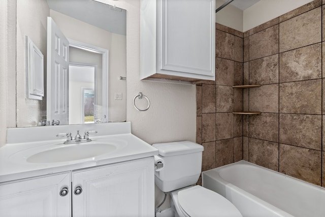 full bathroom with tiled shower / bath, vanity, and toilet