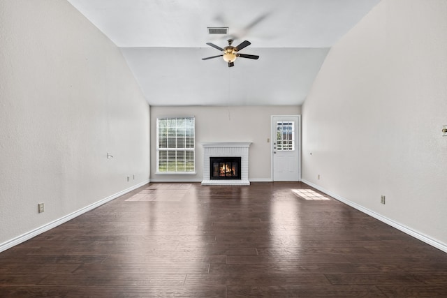 unfurnished living room with dark hardwood / wood-style flooring, a brick fireplace, lofted ceiling, and ceiling fan