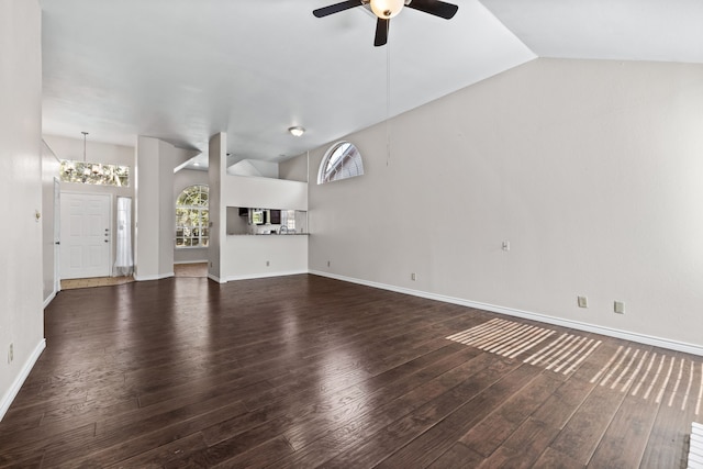 unfurnished living room with dark hardwood / wood-style flooring, ceiling fan with notable chandelier, and vaulted ceiling