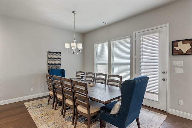 dining space featuring an inviting chandelier and dark hardwood / wood-style flooring