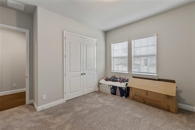 unfurnished bedroom with light carpet and a closet