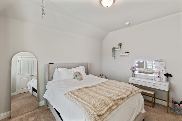 bedroom with lofted ceiling and light carpet