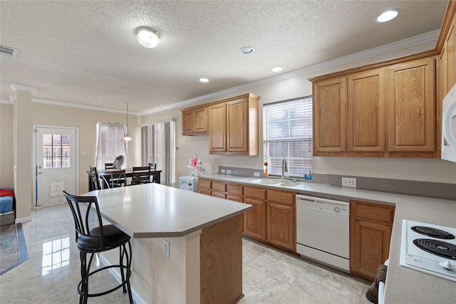 kitchen featuring sink, a kitchen island, pendant lighting, white appliances, and a healthy amount of sunlight