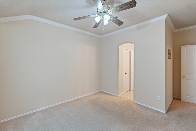 empty room featuring ceiling fan, light colored carpet, and ornamental molding