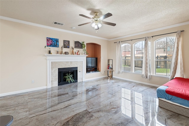 unfurnished living room featuring crown molding, ceiling fan, a fireplace, and a textured ceiling