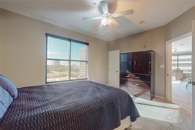 bedroom featuring light colored carpet and ceiling fan