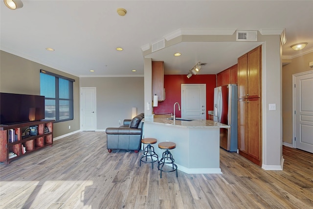 kitchen featuring sink, light hardwood / wood-style flooring, kitchen peninsula, and stainless steel refrigerator with ice dispenser