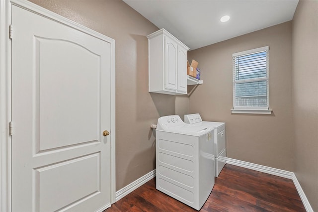 laundry area featuring dark wood-type flooring, cabinets, and washer and clothes dryer