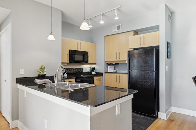 kitchen with dark stone countertops, black appliances, decorative light fixtures, kitchen peninsula, and light brown cabinets